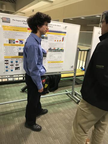 Photo of Aaron discussing his poster