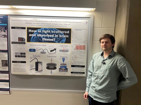 Daniel Keefe standing next to poster