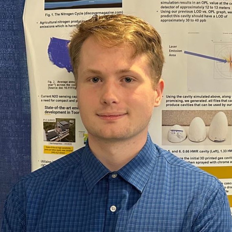 Tyler Nelson posing in front of his research poster